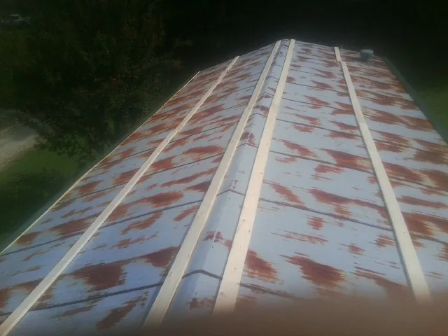 Rusted metal roof panels with new wood purlins before replacement — Storm Damage Roof Repair in Mcpherson by Roofing Brothers