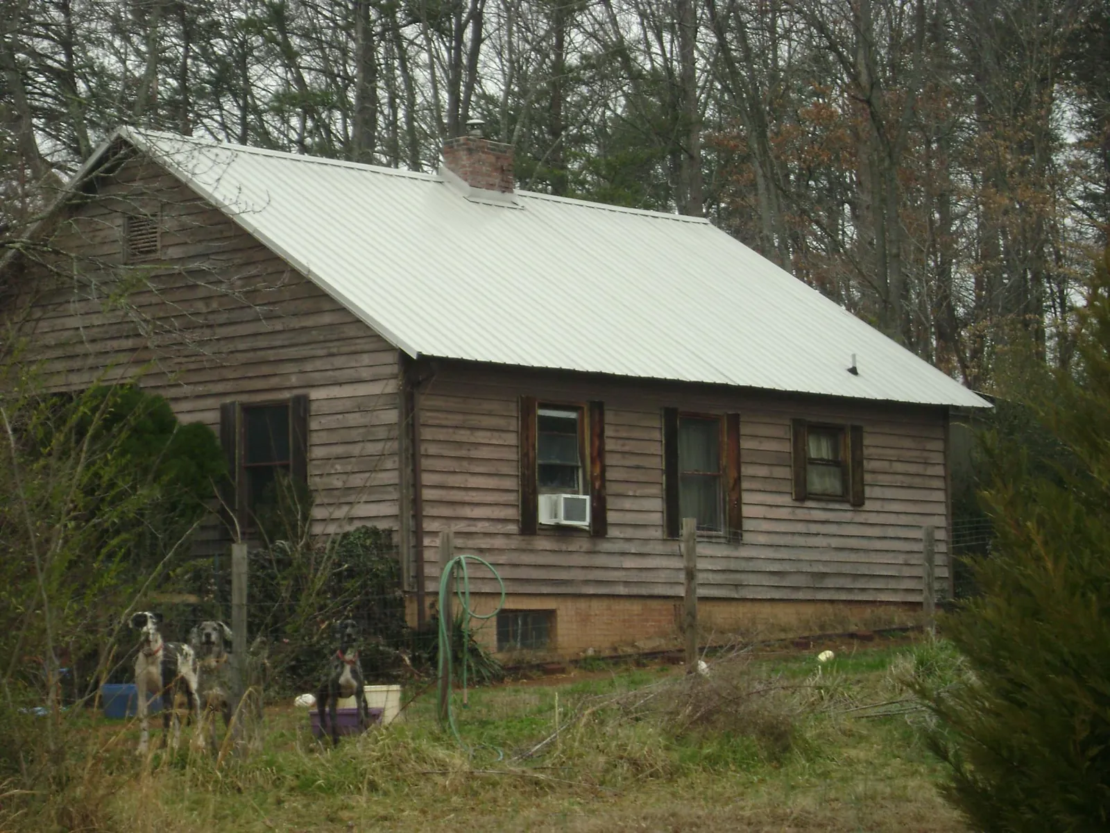White metal roof on an old wood sided farmhouse, from a Metal Roof Installation job in Mcpherson